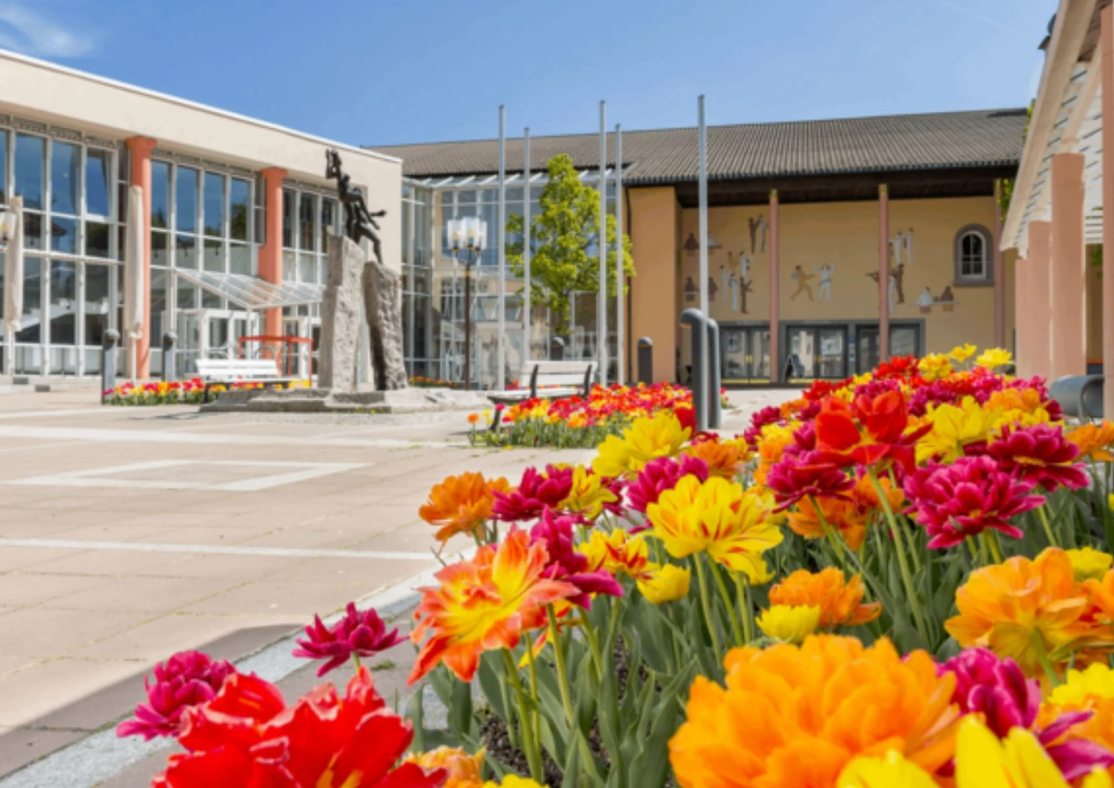 Kurhaus Freudenstadt mit moderner Architektur und blühenden Blumen im Vordergrund bei sonnigem Wetter